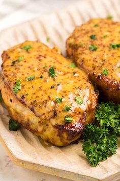 two pieces of meat covered in cheese and parsley