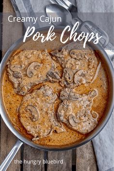 creamy cajun pork chops in a skillet on a wooden table with spoons