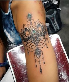 a woman's arm with a tattoo on it that has a flower and feathers