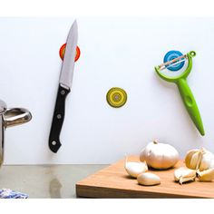 there is a knife and some garlic on the counter next to a pot with a lid