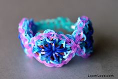 a close up of a colorful bracelet on a gray surface with blue, pink and purple beads