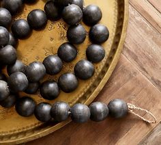 a bunch of metal balls sitting on top of a wooden table next to a string