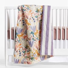 a baby crib with a blanket draped over it