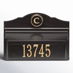 a black and gold mailbox with the letter c on it