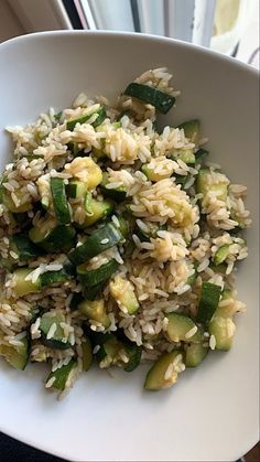 a white bowl filled with rice and veggies