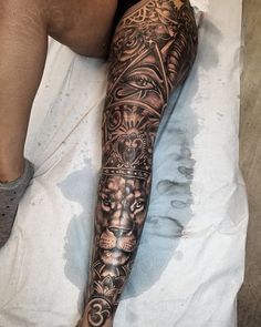 a person laying on a bed with a tattoo on their arm and leg that is covered in tattoos