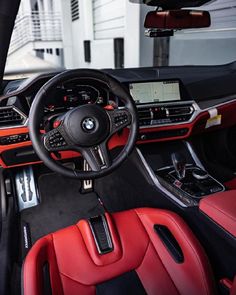 the interior of a car with red leather and black trims, including steering wheel