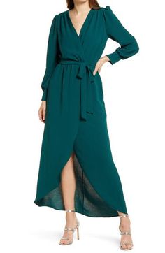 An easy drape and a tulip skirt add casual elegance to this solid-colored dress that's easy to style for fun or fancy, depending on your mood. 44" shortest length; 57" longest length Surplice V-neck Long sleeves Partially lined 100% polyester Hand wash, line dry Made in the USA of imported fabric Dark Teal Long Sleeve Dress, Spring Long Sleeve Solid Wrap Dress, Solid Long Sleeve Wrap Dress For Spring, Flowy Chic Wrap Dress For Fall, Chic High-low Hem Dress For Date Night, Chic Draped Maxi Dress For Fall, Spring Dresses With High-low Hem, Chic Fall Maxi Wrap Dress, Spring Flattering Draped Dress