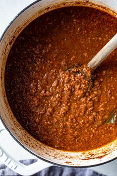 a pot full of chili sauce with a wooden spoon in it