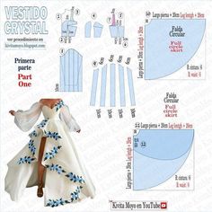 a paper doll is wearing a white dress with blue flowers on the skirt and cape