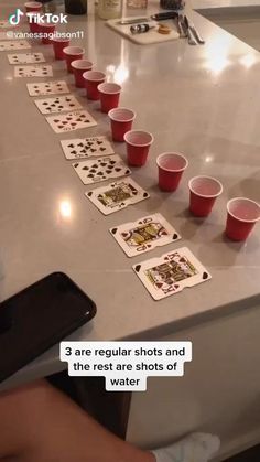 a person sitting at a table with cups and cards in front of them on the counter