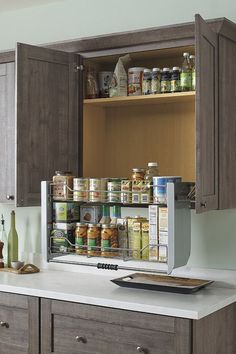 an open cabinet in the middle of a kitchen filled with spices and condiments