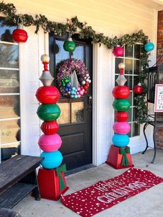 the front door is decorated for christmas with colorful decorations and wreaths on it's pillars