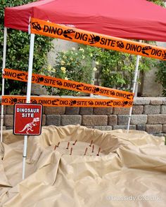 an orange and white sign under a red tent