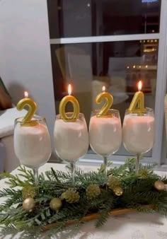 three wine glasses with candles in them sitting on a table