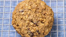 an oatmeal cookie sitting on top of a cooling rack next to a blue towel