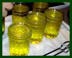 there are many yellow glass jars on the table with spoons next to each other