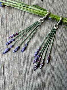 In these Lavender Bouquet Huggies, handcrafted glass lavender flowers dangle from bold hoops designed to closely hug the earlobe.  These lightweight dangles make a playful botanical accessory for gardeners and nature lovers. Each purple glass flower head is sculpted from molten German glass using hand tools and gravity. The individually sculpted flower stalks are one of a kind so size and shape may vary.  As a final touch, each tiny stainless-steel bouquet stem is hand painted. Each pair of 11x14mm Huggie Hoops are hinged, made from .925 Sterling Silver.  Earrings will arrive carded with a purple satin pouch containing fragrant lavender buds. Lavender Bouquet, Lavender Buds, Purple Satin, Final Touch, Purple Glass, Lavender Flowers, Sterling Silver Hoops, Glass Earrings, Jewelry Earrings Hoops