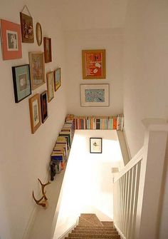 the stairs are lined with books and pictures