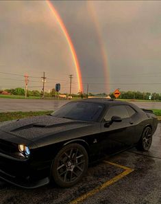 a black sports car parked in front of a rainbow