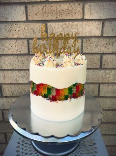 a birthday cake with white frosting and rainbow sprinkles