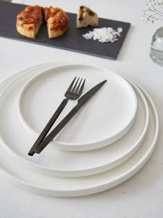 a white plate topped with two pieces of cake next to silverware and utensils