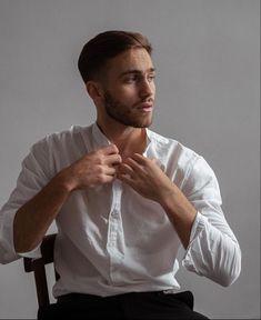 a man sitting in a chair with his hands on his chest