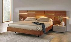 a large bed with wooden headboard and night stands on either side of the bed