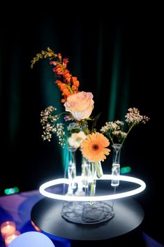 vases filled with flowers sitting on top of a table next to candles and lights