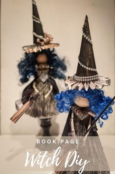 two dolls are dressed up as witches and one is wearing a blue wig, the other has a black hat