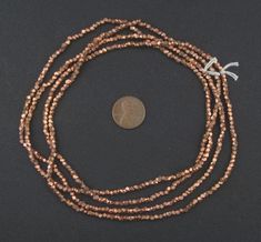 a long strand of beads with a coin on top