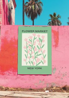 a sign on the side of a building that says flower market new york with palm trees in the background