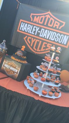 a motorcycle themed dessert table with cupcakes on it