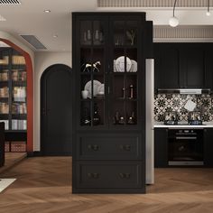 a kitchen with black cabinets and wooden floors