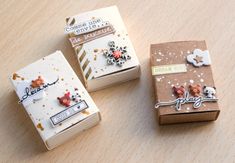 three small boxes sitting on top of a wooden table