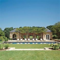 an outdoor swimming pool with lounge chairs and trees in the backgroung area