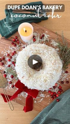 a round cake sitting on top of a wooden cutting board next to a candle and napkin