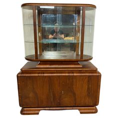 an antique wooden display case with glass doors