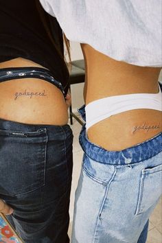 two people with tattoos on their stomachs and one has the words godless tattooed