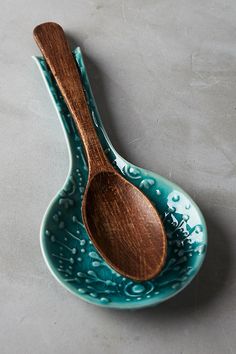 two wooden spoons sitting on top of a blue bowl