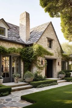 a stone house with lots of greenery on the front