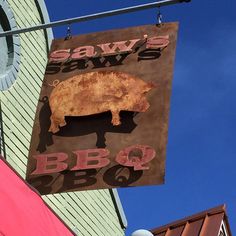 a sign hanging from the side of a building that says saw's saws bbq