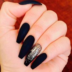 a woman's hand with black and gold nails