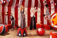 a group of circus performers standing in front of an american flag