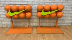 two orange basketballs with green arrows on them in front of a brick wall