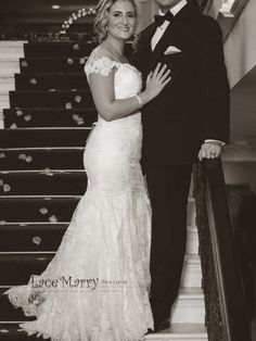 black and white photo of bride and groom posing on the stairs at their wedding reception