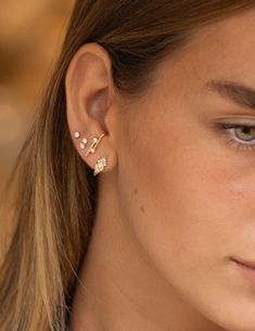 a close up of a person wearing some kind of earring with pearls on it