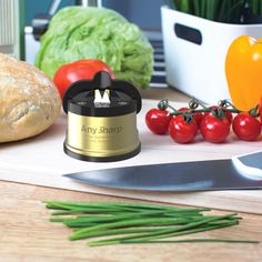 an array of vegetables and bread on a cutting board next to a knife, tomatoes, lettuce