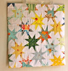 a quilt hanging on the wall next to a pair of scissors