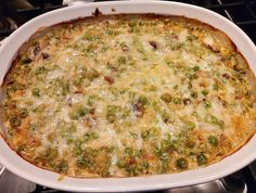 a casserole dish with peas and cheese in it on top of the stove